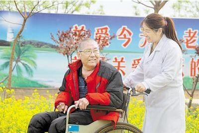 在巨鹿县小吕寨镇养护中心，护理员陪着一位老人在院里散心遛弯。 巨鹿县人社局供图