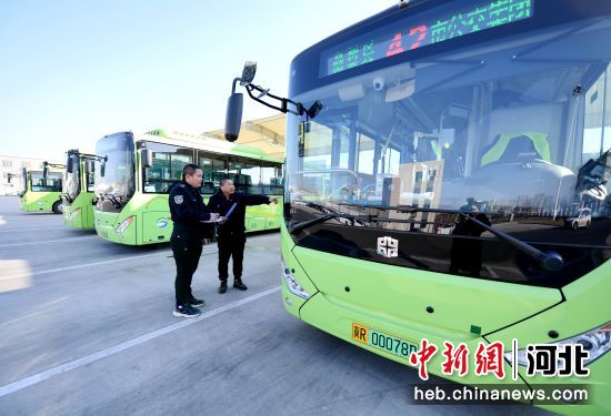 图为公交安检员对新能源电动公交车进行出车前安全技术检查。 赵亮 摄