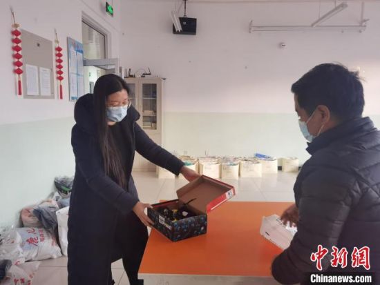 图为蔚县益海助学中心的老师为孩子们选购的新鞋�！±钛� 摄