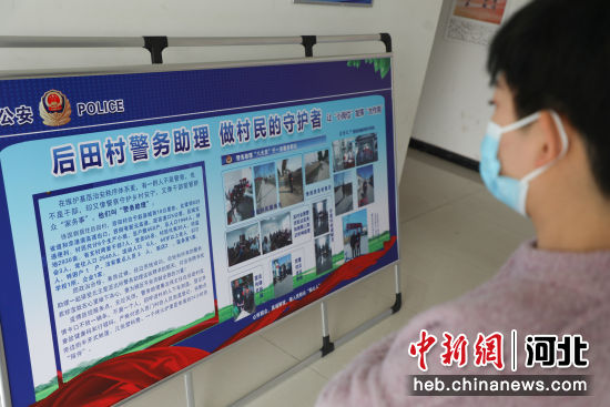 在河北省石家庄市赵县后田村，村民正在观看“一村一警务助理”宣传展板。 朱涛 摄