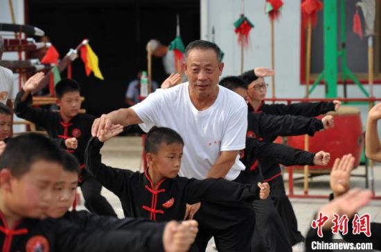 图为老武师正在指导武术班学员的动作。　肃宁县委宣传部供图