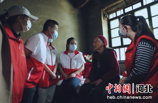 图为志愿者聆听建国前老党员讲述红色故事。 刘巨雷 摄