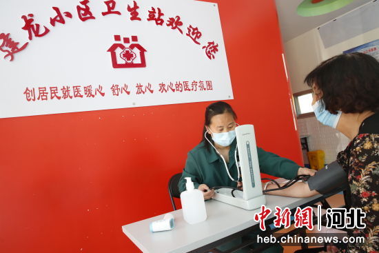 兴隆县建龙小区卫生站内，医生正在为居民测量血压 作者 吴亚平