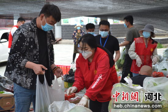 偏桥子镇干部职工将村民捐赠的蔬菜进行分装打包。 王健
