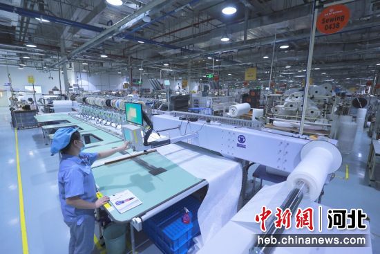 图为廊坊经济技术开发区一企业车间内工作人员在缝纫生产线上忙碌着。 陈童 摄