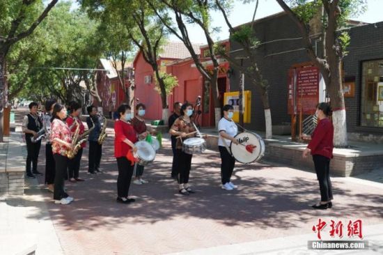 图为5月26日，周窝村村民组建的西洋乐队在街头演奏。 中新社发 徐鹏璐 摄