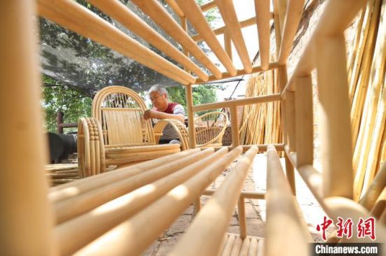 图为廊坊市安次区调河头镇南马庄村一蜡杆加工厂，工人正在制作蜡杆逍遥椅。　贾�B 摄