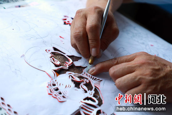 唐山市市级非物质文化遗产代表性传承人蒋风山正在剪刻作品。 刘兰伟 摄