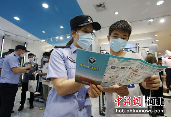 图为河北省邯郸市永年区公安局民警正在辖区商场向居民讲解禁毒知识。 作者 胡高雷