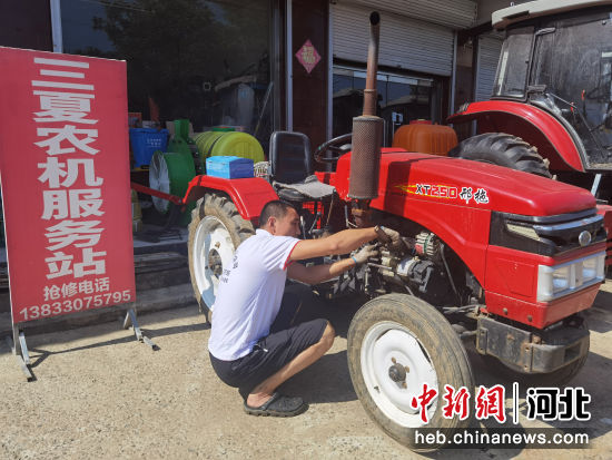 图为技术人员在维修农用机械。 李宗岳 摄
