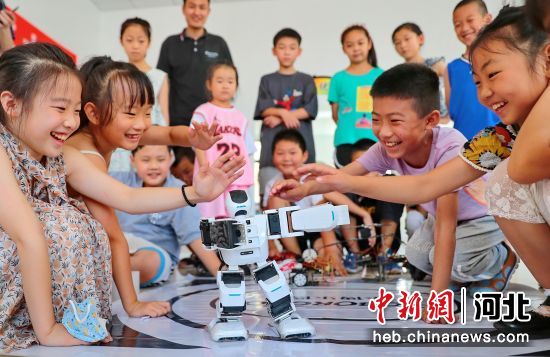 图为小朋友正在观看机器人跳舞。 曹建雄 摄