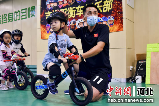 图为青县小学生在平衡车兴趣课上和教练学习弯道过弯技巧。 作者 尹向平