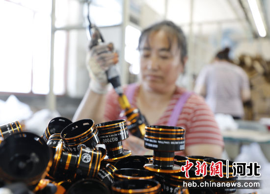 图为在固安县礼让店乡龙凤渔具有限公司生产车间，工人正加工纺线轮。 吴迪 摄