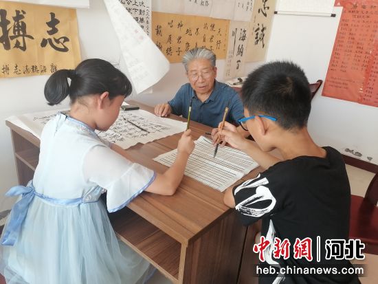 图为东光县后屯村农家书屋内，书法爱好者正在指导孩子们练习毛笔字。 田俊荣 摄