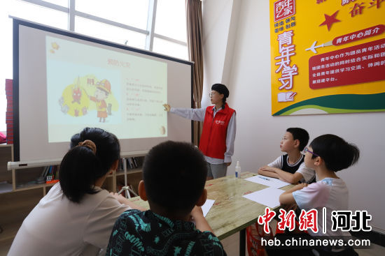图为青县青年中心暑托班内，小学生们认真聆听大学生志愿者讲解安全自救知识。
