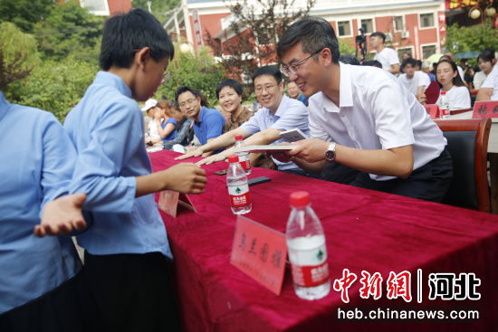 图为诗上庄的孩子们向来宾赠书《中国有个诗上庄》。 吴亚平摄