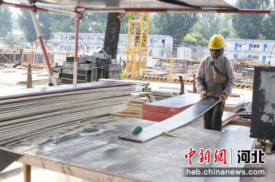 图为永清县林栖康旅中心项目建设现场，建筑工人正在切割板材。 庞趁友 摄