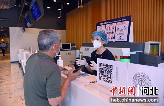 图为北京大兴国际机场廊坊城市航站楼工作人员正在为旅客介绍航班信息。 作者 李永辰