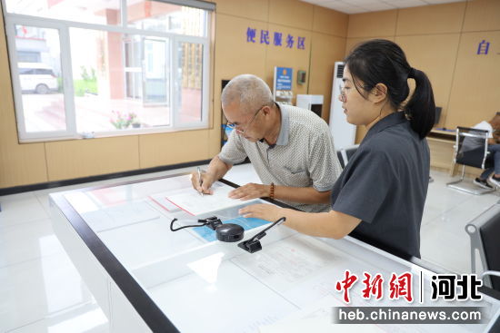 兴隆县人民法院诉讼服务中心内，老人在导诉员的帮助下办理业务。 殷子曦 摄