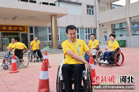 图为在希望之家脊髓损伤者生活重建训练营，参训学员在练习端水杯轮椅绕桩。 作者 鲍俊秀