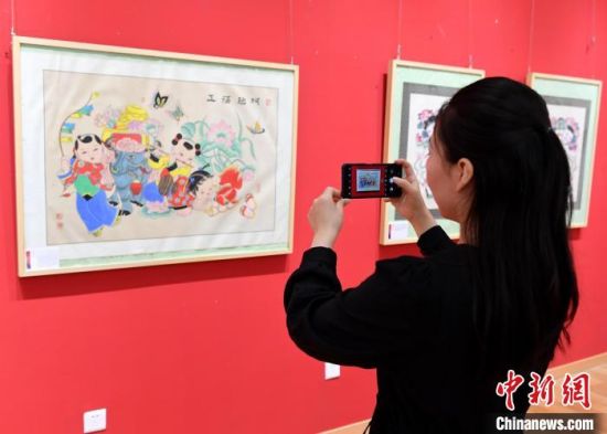 在河北武强年画博物馆展厅内，参观者在对绵竹木版年画拍照留念。　苏小立 摄