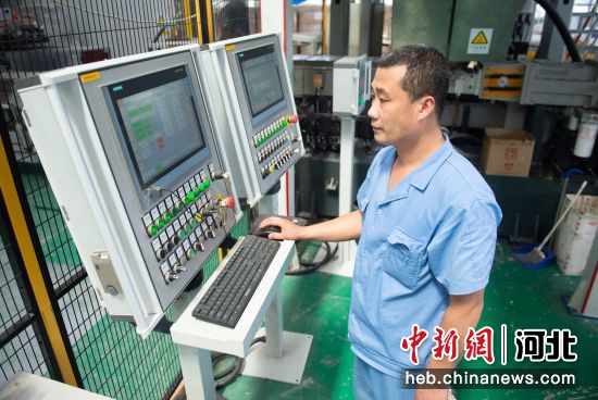 图为工作人员在枣强县工业设计创新中心调试玻璃钢自动化生产设备。