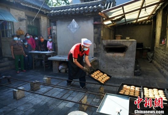 图为9月6日工人正在摆放新出炉的月饼。 中新社记者 翟羽佳 摄