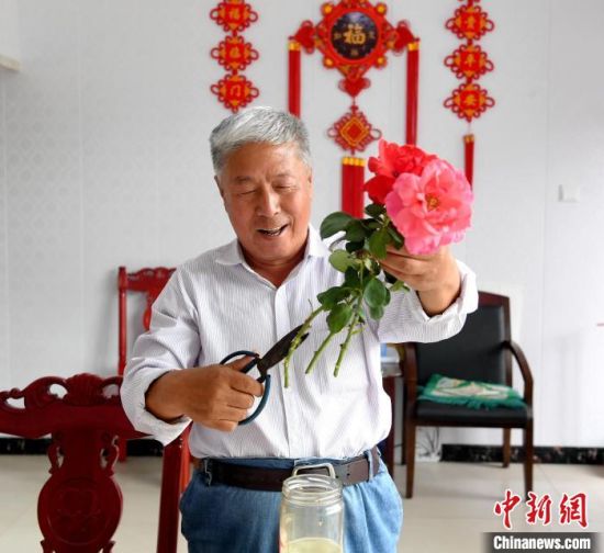 “互助幸福院”的一位老人在修剪鲜花。　苗凤强 摄