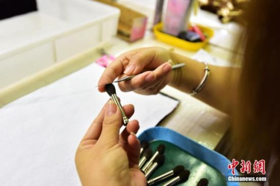 资料图为2022年6月9日，青县某制刷厂员工使用刻刀对化妆刷进行修型。 中新社发 尹向平 摄