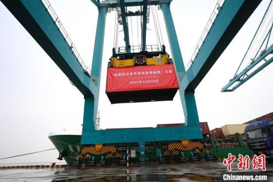 图为在黄骅港津冀国际集装箱码头，桥吊在吊装黄骅港首条外贸集装箱航线的首箱货物。　赵俊杰 摄