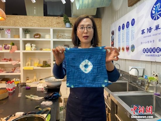图为10月28日，段惠展示草木染及传统扎染技艺制作的蓝布。 中新社记者 李晓伟 摄