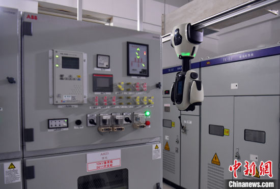 图为10月11日，雄安新区昝西220千伏变电站内，吊轨机器人正在进行巡检。 中新社记者 韩冰 摄