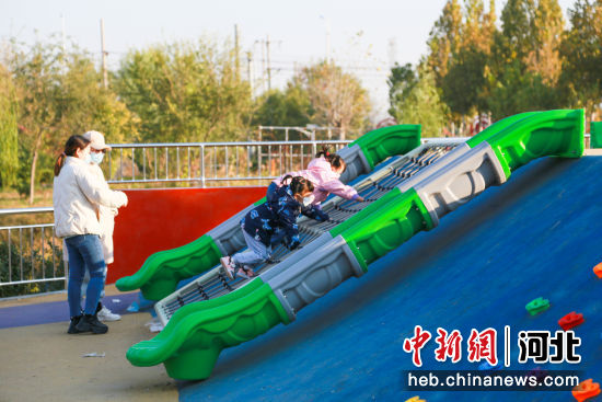 图为东光县“口袋公园”内，孩子们正在家长的看护下滑滑梯。 作者 陈英华