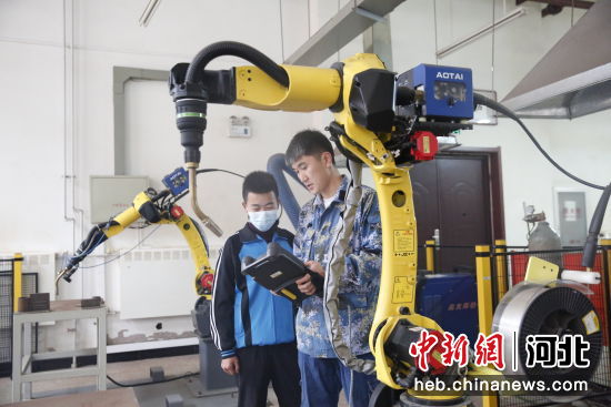 在兴隆县职教中心，焊接专业的学生在老师的指导下进行机器人焊接实训 作者 杨旭