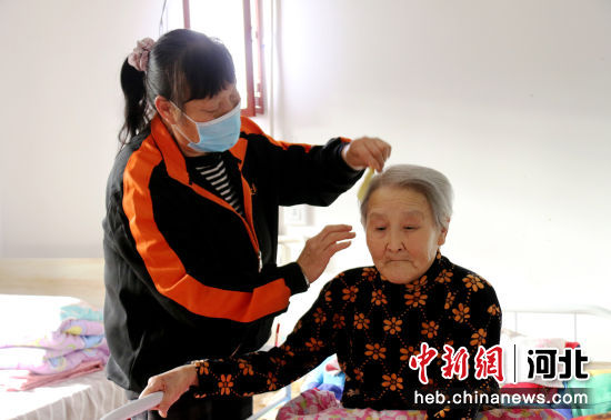 图为永清县仁爱老年人服务中心内，工作人员正在为行动不便的老人梳理头发。 作者 庞趁友
