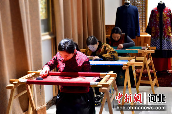 在河北省隆尧县北楼乡一家服装加工企业，绣娘在绣坊绣制京绣作品。 作者 潘志方