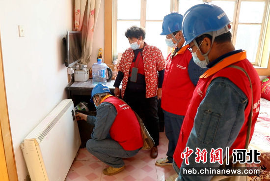 工作人员为“煤改电”用户检查取暖设备。 薛腾飞 摄