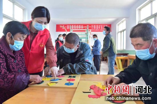 志愿者在井陉矿区日间照料中心帮助残疾人进行康复训练。 张晓峰 摄