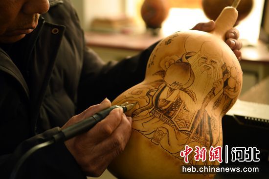 图为广平县民间艺人龙常青在制作葫芦烙画。 武小凯 摄