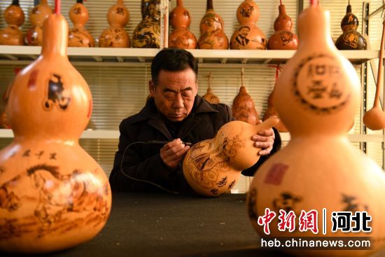 图为广平县民间艺人龙常青在制作葫芦烙画。 武小凯