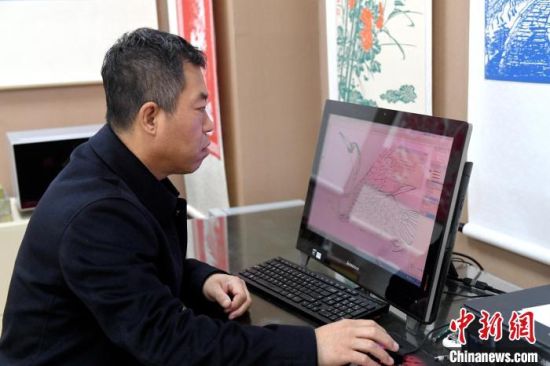 刘建国用电脑设计鸬鹚的图案。　崔贤飞 摄
