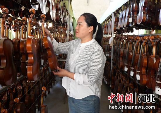 武强县一乐器企业工人在整理乐器。 贾枭梦 摄 武强县一乐器企业工人在整理乐器。 贾枭梦 摄