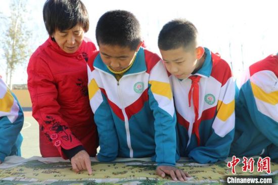 11月28日，赵卫平走进学校给学生介绍十字绣作品《清明上河图》。刘延岭 摄