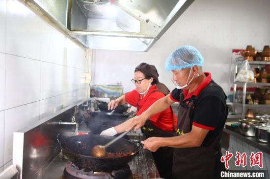 10月10日，在河北沧州青县一家火锅鸡店里，厨师正在炒制火锅鸡。薛强 摄