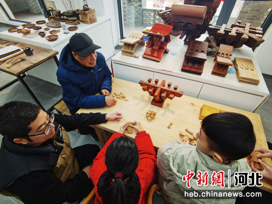 图为家长和学生共同体验易县西庄村古建筑木工技艺。 吕子豪 摄