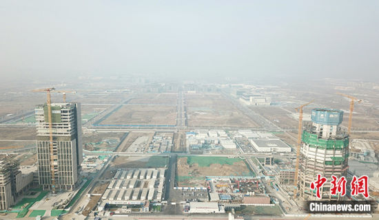 3月27日，位于雄安新区启动区的中国中化总部大厦项目完成主体结构封顶，较计划节点提前1个月。资料图为2月8日，航拍中国中化总部大厦项目(右)建设现场。(无人机照片) 中新社记者 韩冰 摄