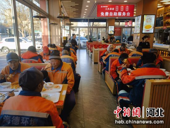 图为环卫工人来在爱心餐饮店内吃早餐。 韩新华 摄
